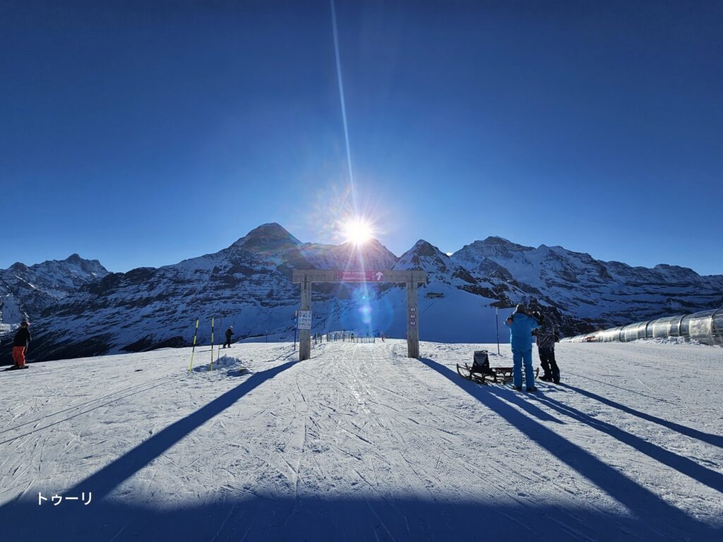 A wooden gate at Kleine Scheidegg with snow-covered peaks — a mountain area accessible by private tour