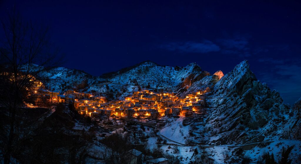 雪に包まれた山岳リゾートの夜景とクリスマスの灯り