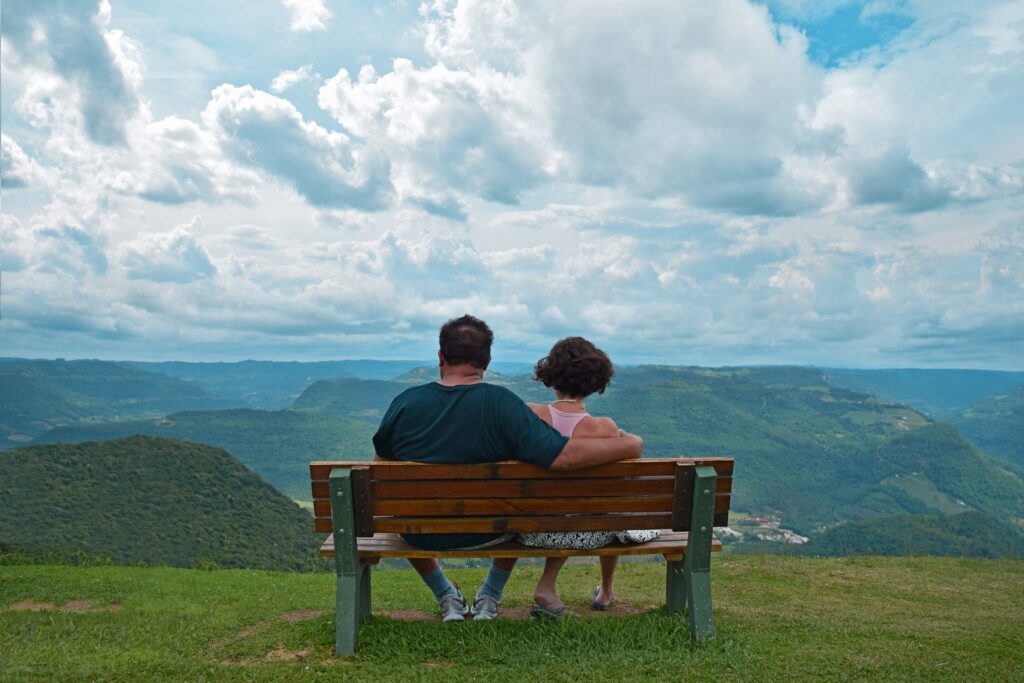 Couple watching a Swiss mountain sunset from a bench, an ideal scene for honeymoons